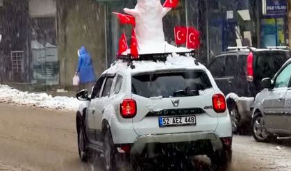Aracının üzerine yerleştirdiği kardan adam ile şehir turu attı